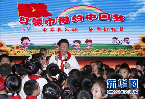 （2014年5月30日，习近平来到北京市海淀区民族小学，参加庆祝“六一”国际儿童节活动。这是习近平在参加少先队入队仪式时，向少先队员们致以节日问候。 新华社记者 鞠鹏）